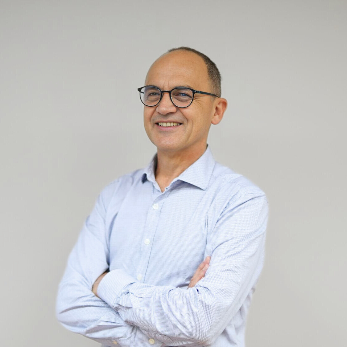 photo de trois quart de Christophe HEUBERGER, souriant et les bras croisés.