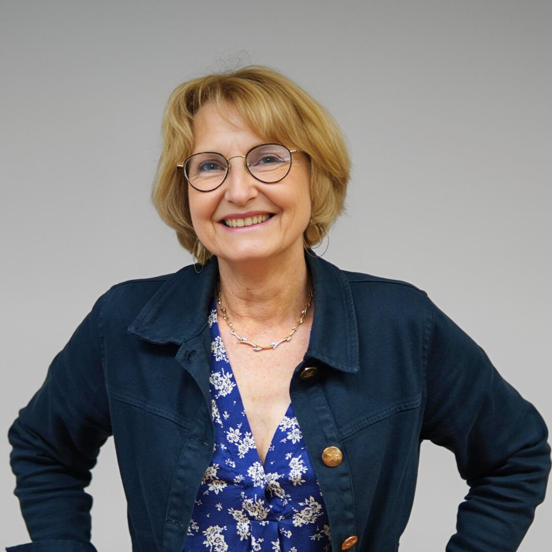 photo de face de Joelle HEUBERGER, souriante et les mains posées sur les hanches.